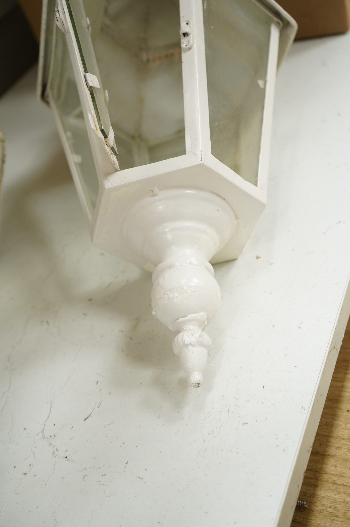 A pair of hexagonal painted hanging lanterns with glass panels, 54cm high